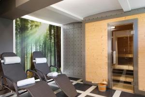 a room with chairs and a mural of trees at Kurhaus Masserberg in Masserberg