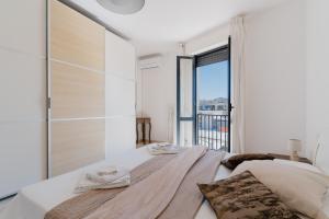 a bedroom with a large bed with a large window at Casa Idrusa a Otranto in Otranto