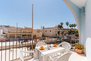 a balcony with a table and chairs and a view of the beach at Casa Idrusa a Otranto in Otranto