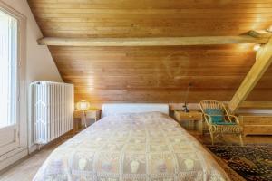 a bedroom with a bed and a wooden wall at Grande maison familiale in Douarnenez