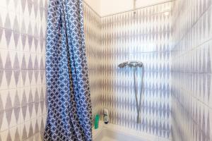 a bathroom with a shower with a blue shower curtain at Grande maison familiale in Douarnenez +26 photos