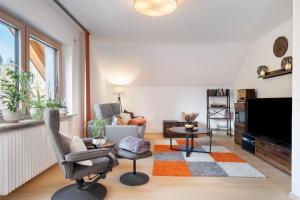 a living room with a couch and a tv at Fewo Kessler Waldblick in Häusern