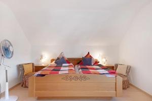 a bedroom with a wooden bed with two pillows at Fewo Kessler Waldblick in Häusern