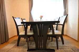 a black dining room table with chairs and a window at 心宿 伏見稲荷 in Kyoto