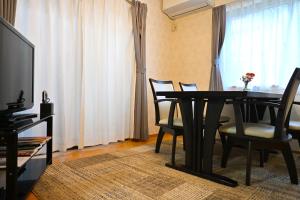 a living room with a table and chairs and a television at 心宿 伏見稲荷 in Kyoto