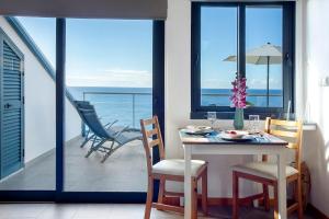 a dining room with a table and chairs on a balcony at The Wave House - Oceanfront in Jardim do Mar