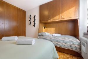 two beds in a bedroom with wooden cabinets at La finestra sui monti - Breguzzo in Breguzzo