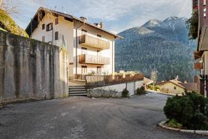 a building on a street with mountains in the background at La finestra sui monti - Breguzzo in Breguzzo