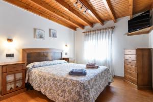 a bedroom with a bed and a dresser and a television at Huerta El Pozu in Soto de las Dueñas +95 photos
