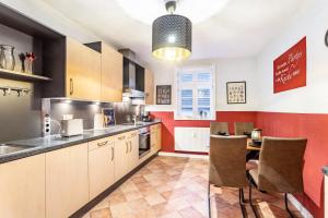 a kitchen with red walls and a table and chairs at Ferienwohnung im Torwärterhäuschen in Rüthen