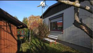 a bench sitting in front of a building at Landhaus Eva-maria in Elbingerode +2 photos