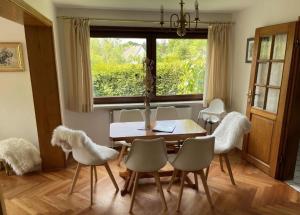 a dining room with a table and chairs and a window at Landhaus Eva-maria in Elbingerode