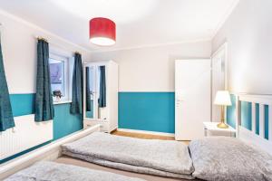 a bedroom with two beds and blue walls at Ferienwohnung im Torwärterhäuschen in Rüthen