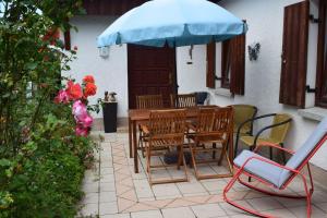 a patio with a table and chairs and an umbrella at Landhaus Eva-maria in Elbingerode
