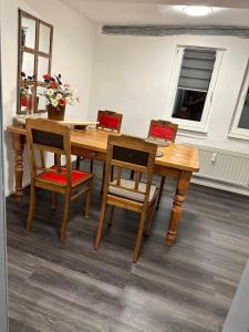 a wooden dining room table with four chairs at Charmante Ferienwohnung im Gässchen in Rudolstadt +5 photos