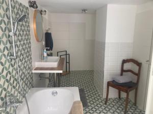 a bathroom with a tub and a sink and a chair at Charmante Ferienwohnung im Gässchen in Rudolstadt