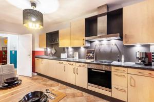 a large kitchen with wooden cabinets and appliances at Ferienwohnung im Torwärterhäuschen in Rüthen +19 photos
