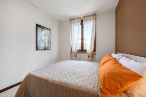a bedroom with a bed with an orange pillow at vista lago apartment 1 in Soiano del Lago