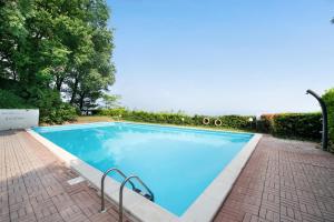 a swimming pool with blue water in a yard at vista lago apartment 1 in Soiano del Lago