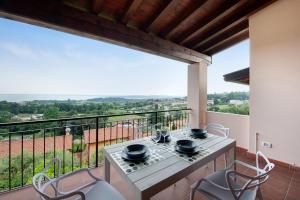 a balcony with a table and chairs and a view at vista lago apartment 1 in Soiano del Lago