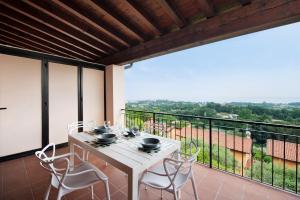 a white table and chairs on a balcony with a view at vista lago apartment 1 in Soiano del Lago
