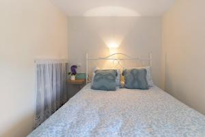 a bedroom with a bed with a blue blanket and pillows at Quinta Natureza de Coura in Paredes de Coura