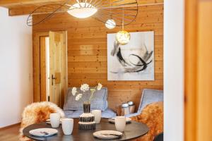 a dining room with a table and a chandelier at Chalet Flocke Appart Schneehase in Sankt Anton am Arlberg +20 photos