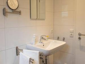 a bathroom with a sink and a mirror and towels at Hof Weuste Fewo Lister in Attendorn +14 photos