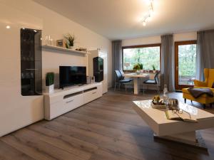 a living room with a television and a living room with a table at Hof Weuste Fewo Lister in Attendorn
