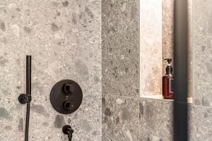 a shower with a glass door with a bottle of soap at Chalet Flocke Appart Schneehase in Sankt Anton am Arlberg