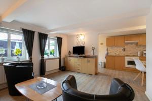 a living room with a table and a kitchen at Ketelsens Ferienwohnung in Bohmstedt