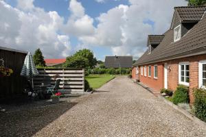 a gravel driveway next to a brick house at Ketelsens Ferienwohnung in Bohmstedt