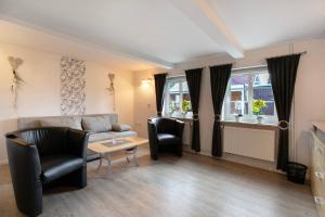 a living room with a couch and chairs and a table at Ketelsens Ferienwohnung in Bohmstedt