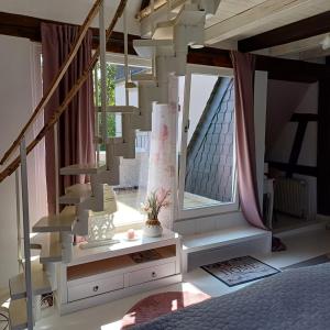 a living room with a staircase and a window at Auszeit Rheingauer Rosengarten in Geisenheim