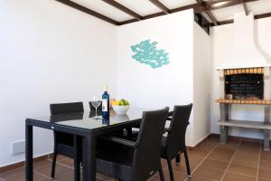 a dining room with a black table and chairs at Villa Eris in Puerto del Carmen