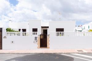 a white house with a gate and a door at Villa Eris in Puerto del Carmen