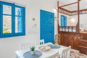 a dining room with blue doors and a table and chairs at Avlona Blue in Diafani