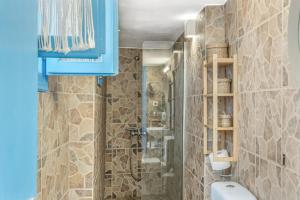 a bathroom with a shower and a toilet and a blue cabinet at Avlona Blue in Diafani +20 photos