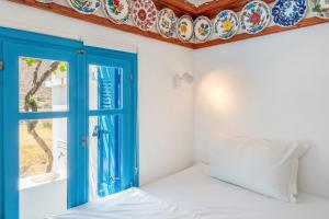 a bedroom with a blue door and a window at Avlona Blue in Diafani