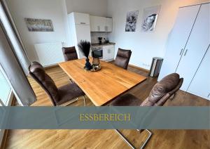 a dining room with a wooden table and leather chairs at Flexi Flats in Lingen