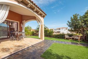 a patio with an archway and a table and chairs at Casa a schiera Budoni in Budoni