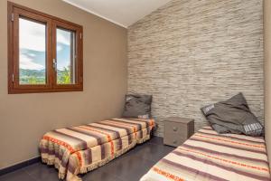 a room with two beds and a window at Casa a schiera Budoni in Budoni