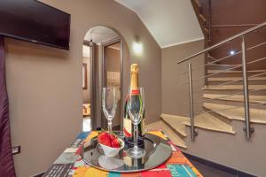 a table with a bottle of wine and a glass at Casa a schiera Budoni in Budoni +17 photos