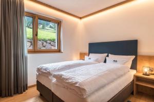 a bedroom with a large bed and a window at Apt Lara Siela in Ortisei