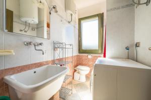 a bathroom with a white sink and a toilet at Villetta Stella in Chia +20 photos