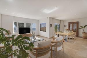 a living room with a table and a tv at Villa Spinnaker Playa in Puerto de Santiago
