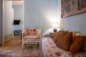 a bedroom with a bed and a chair and a lamp at Rosaspina - Appartamento 7 in Capalbio