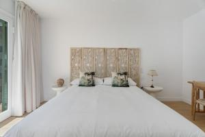 a bedroom with a large white bed with two pillows at Villa Spinnaker Playa in Puerto de Santiago