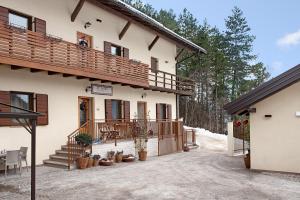 a house with a balcony and a patio at Wellness Lodge Chicca in Santa Giuliana