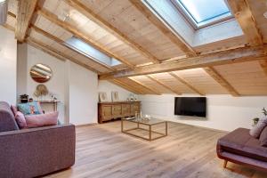a living room with a couch and a tv at Wellness Lodge Chicca in Santa Giuliana
